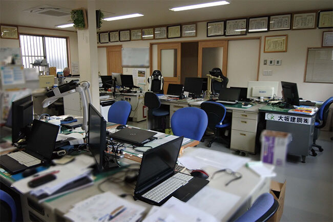 社員が工事現場に出向いた後の社内。ノートパソコンにモニターを連結してデュアルモニターにしている社員が多い