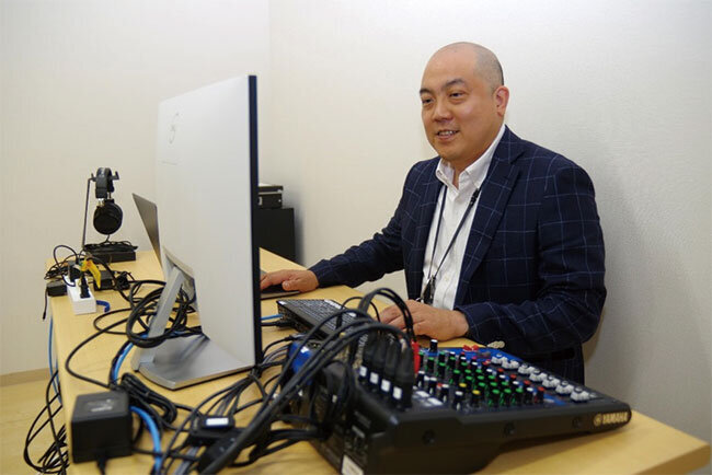 動画配信スタジオの機器に触れる清水正樹代表取締役