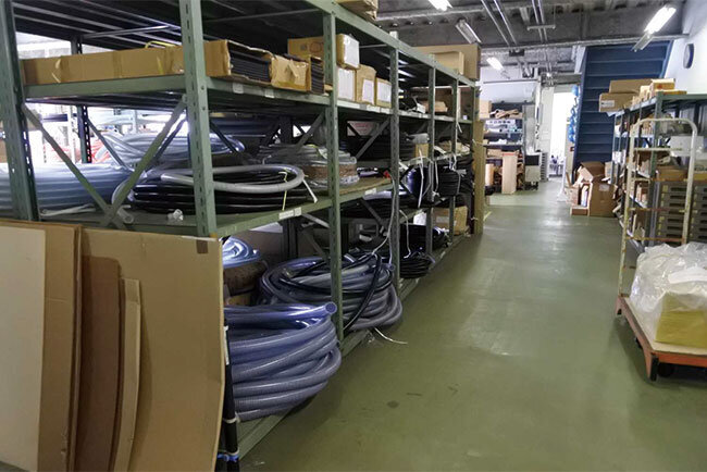 倉庫の棚にはホース類が並ぶ
