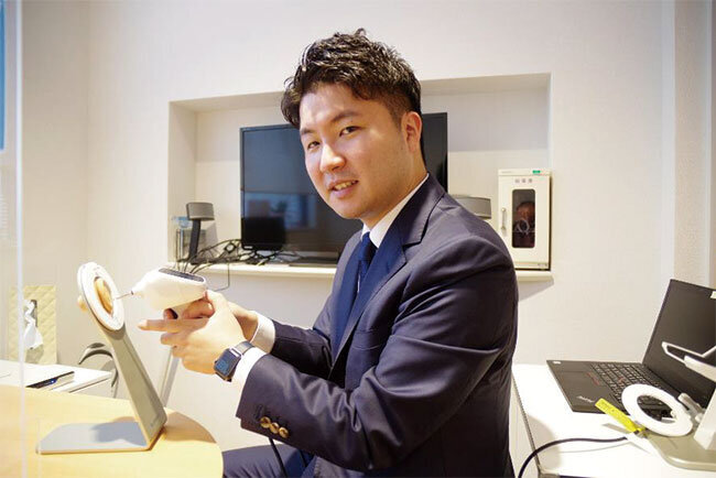 耳の中の形を3Dスキャンする機器を手にしたサウンドパレット株式会社の池上孔規社長