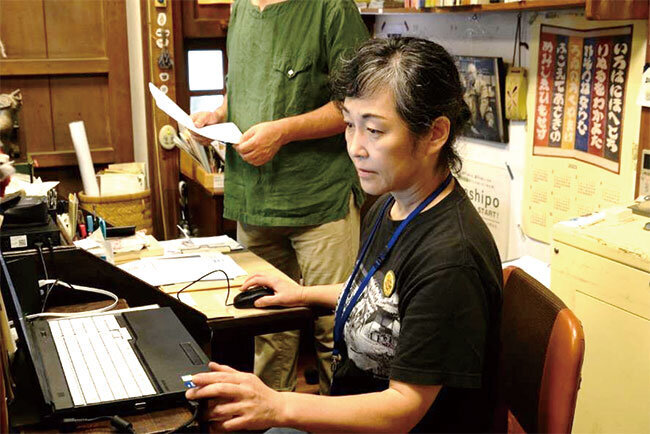 事務作業を共に担うスタッフ。報告書作成やメディア対応にはさまざまなデータが求められ、イベントの記録写真の管理も欠かせない