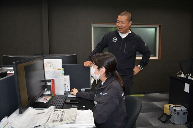 スタッフと談笑する千田専務。「今あるものを良好な状態で次世代へ引き継ぎたい」という