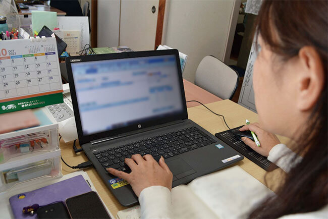 帳票をチェックする藤原さおりさん。データがクラウドに保存され、迅速な対応にも役立つという