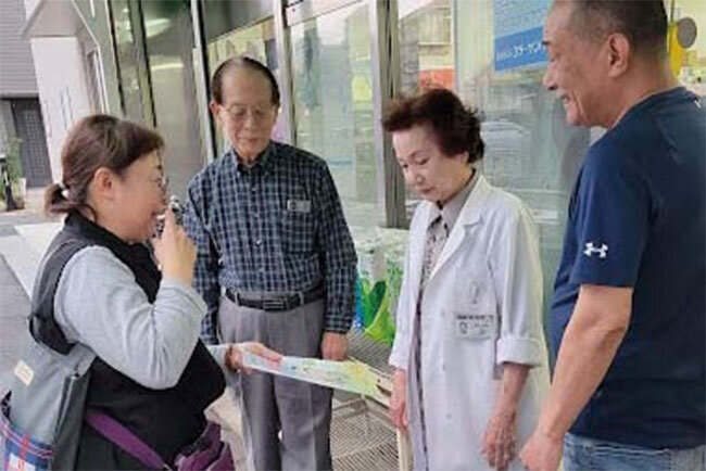 町内会長の飯塚正彦さん（左から2人目）ら住民と話す高橋さん（左端）。地域のお年寄りらの相談を受けるのも重要な仕事だ