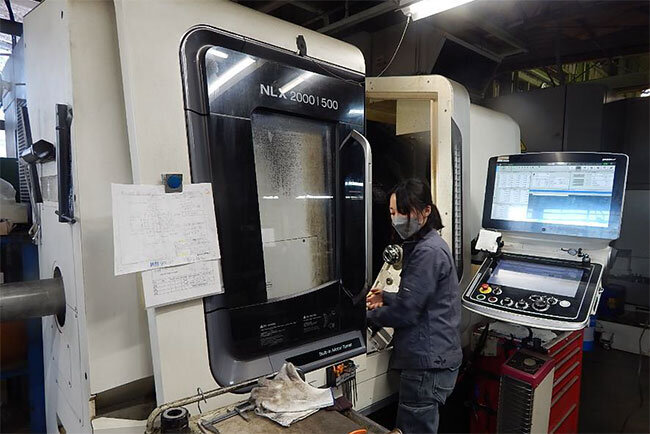 4軸複合旋盤を扱う女性技術者