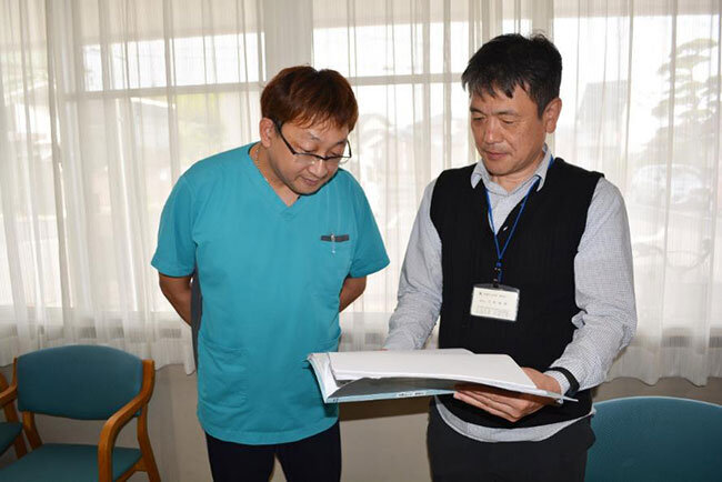 新しい勤怠管理ソフトについて話す日浦靖介護主任（左）と穴吹事務長