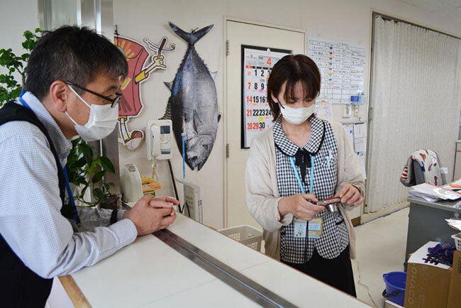 2階の介護スペース事務室。介護職員と入所者のレクリエーションについて話す穴吹事務長