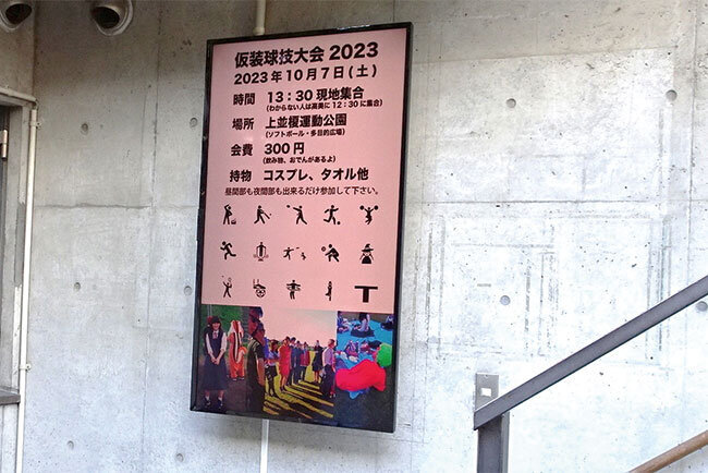 学生が必ず通る階段の横に55インチのデジタルサイネージを設置