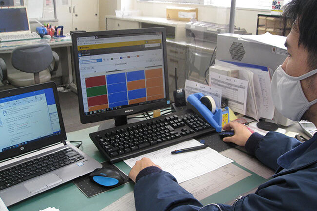 駐車予約システムをチェックする麒麟倉庫の社員