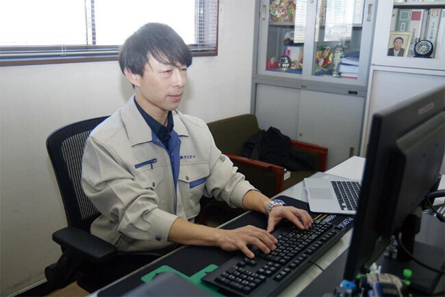 パソコンに向かう中西聡之社長。大学卒業後にしばらく勤務したカー用品販売会社で学んだパソコンを使った業務管理の方法をサンエイに持ち込んだ