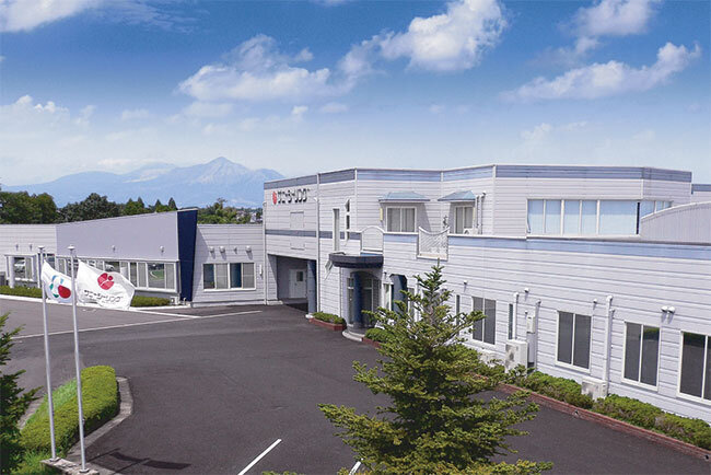 サニー・シーリングは地方都市のハンディキャップをものともせず、品質と技術で「世界水準」をうたう。都城盆地の社屋からは遠くに霧島連山が望める。