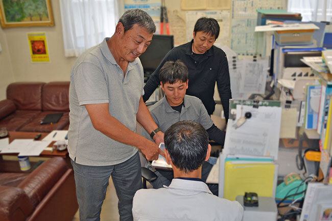 社員と進行中の工事について話す犬養社長（左端）