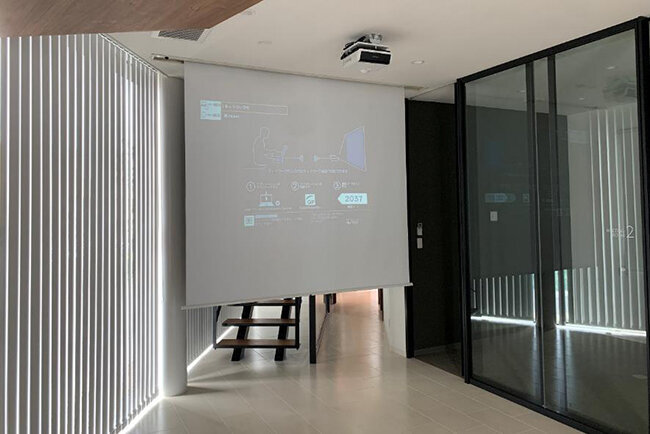 大画面のプロジェクタースクリーン。地域貢献イベントを検討中だ