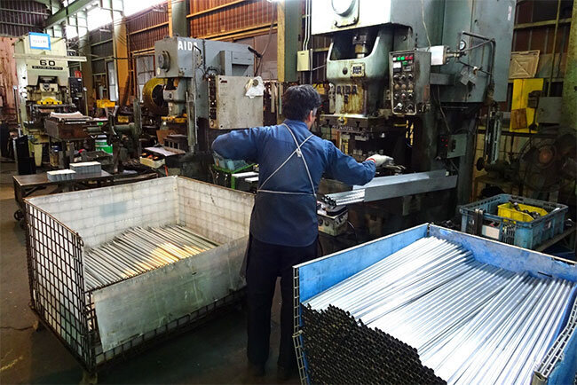 道路脇に建てるアルミ製フェンス資材の製造も、独自の工夫を重ねて小型プレス機で加工する