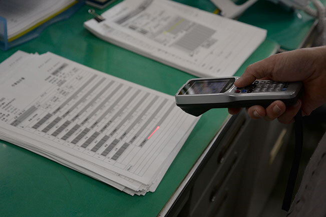 受注した商品はバーコードリーダーにて読みとり、システム上で情報が一元管理される