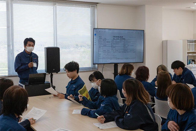 月1回、従業員全員が参加する「社内全体品質会議」の開催風景（韮崎電子提供）