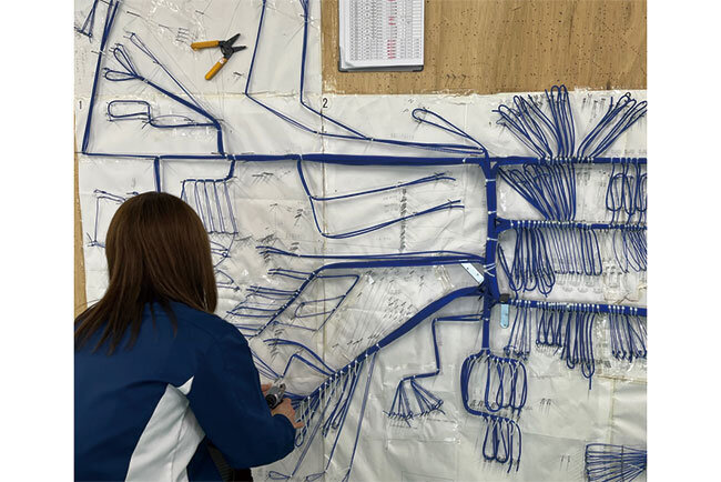 装置の束線作業。韮崎電子は装置に直接配線せずに装置配線を平面に置き換えて作業する