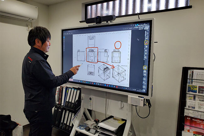 電子黒板の画面に加筆する山本社長。グループ会社や取引先とのWeb会議で電子黒板は大活躍している