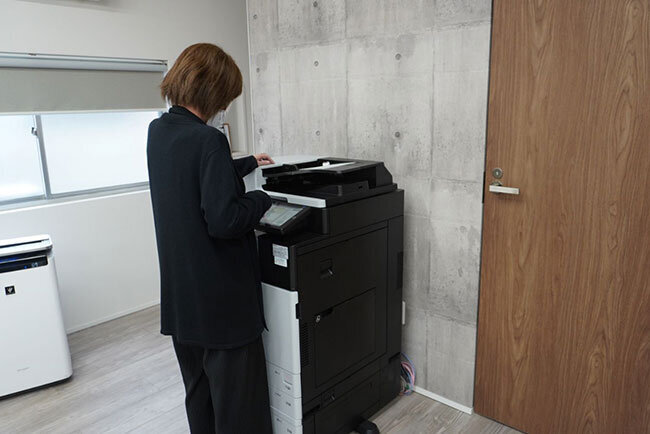 新しく導入した複合機を使って紙文書をスキャンする様子