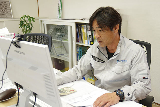 パソコンに向かう伊藤電設の伊藤法之社長