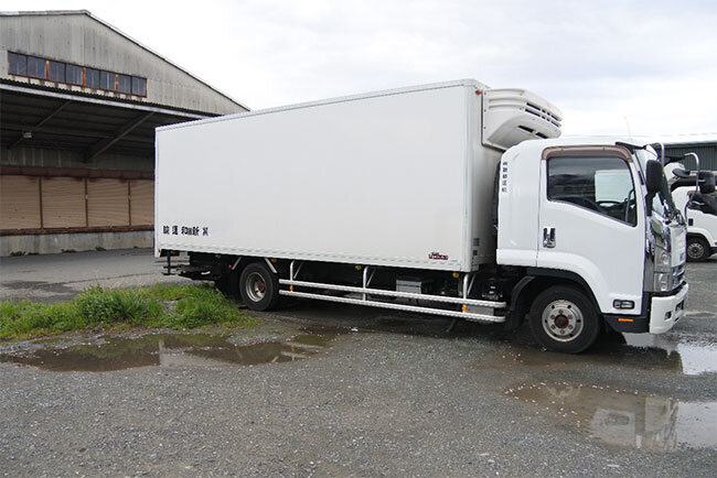 冷蔵4トン車。白いボディに社名だけを黒色で表示