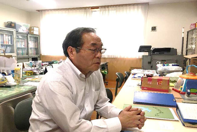 職員室で開園の経緯と抱負を語る八須園長