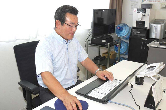 パソコンに向かって作業する高橋千明専務理事