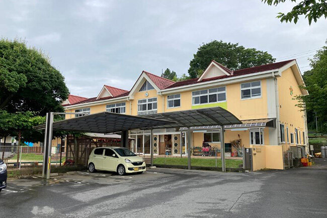 赤い屋根と中央にある丸い時計が印象的な北浦こども園の園舎。藤崎園長の思い浮かべる昭和初期ごろの「昔の小学校」をイメージしてデザインされたという