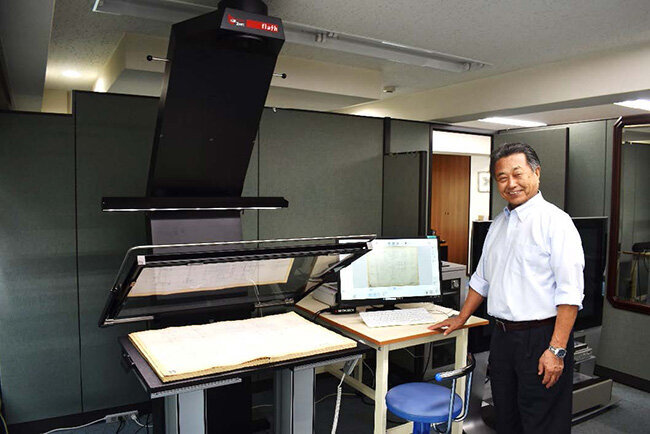 ドイツマイクロボックス社製の高速・高画質カラーブックスキャナーについて説明するシステム・プランニングの森弘英雄社長