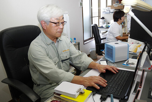 パソコンに向かう峯岸工務店の峯岸社長