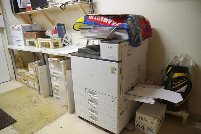 フラワー紅白の社内におかれたオンデマンド印刷機、奥に以前使っていたプリンターを予備機として残してある