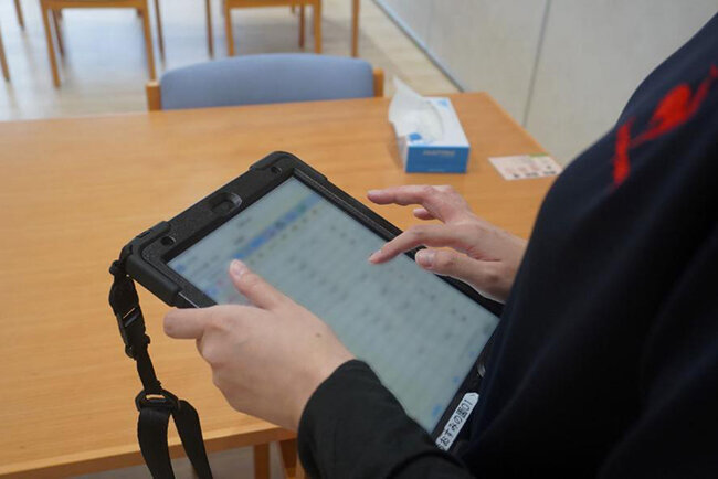 入所施設おおすみの園でタブレット端末を使って記録を入力する様子