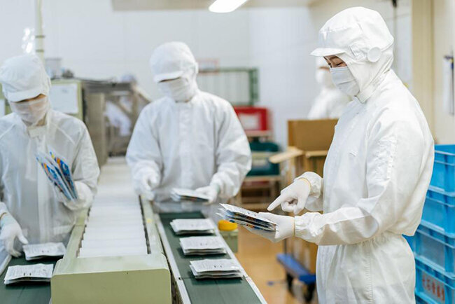 製造現場で医薬品を包装する様子