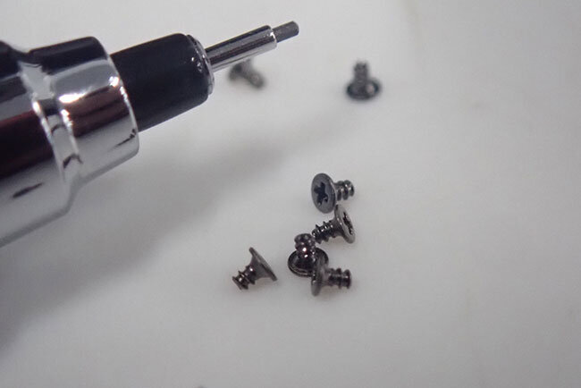 シャーペンとネジ　直径0.8ミリメートルの微小ネジの不良品も徹底した検査で見つけ出す（左上は0.5ミリメートルのシャープペンシルの芯）