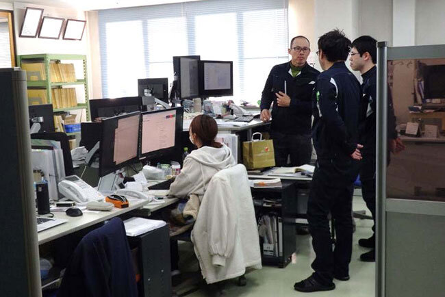 山和エンヂニアリング本社の事務フロアで打ち合わせする社員。業務のDX化で社員間の情報共有が大幅に向上している