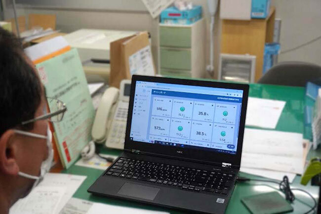 センサーが取得したデータを基に事務室で教室の空気環境を確認する様子