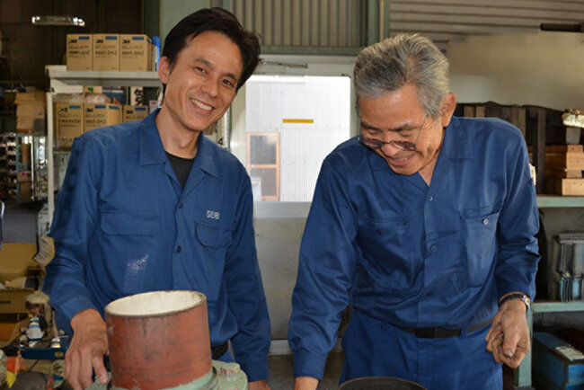 藤井憲師さん（右）と話す浅田社長。「この部品の点検結果は良好です」