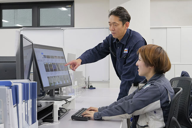 綿貫さんの作業指示に従って施工管理システムを操作する山脇さん