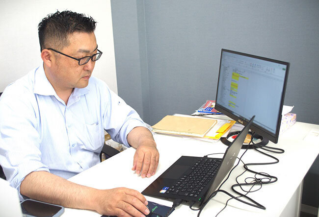 パソコンを使った作業で、顧客企業の管理状況や課題の進捗状況などをチェックする萩原代表