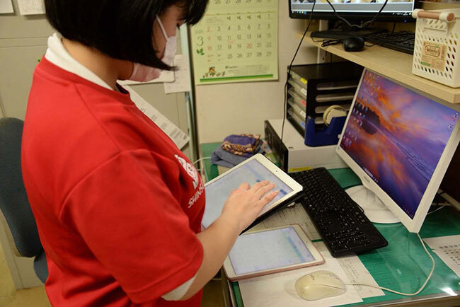 大規模修繕を機に全館にWi-Fiが設置され、どこからでもICT機器での通信が可能に。職員は入所者の食事や入浴、排泄記録をタブレット端末でリアルタイムに記録している