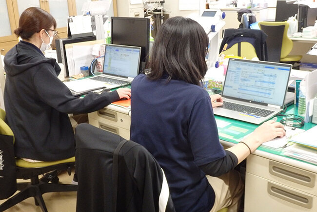 一新した介護業務支援ソフトを使って事務作業に当たる明光会の職員