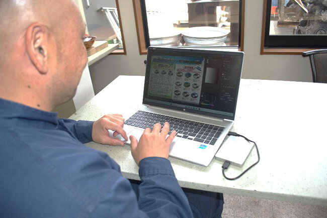 新規顧客獲得のためのチラシ作りをパソコン上で行う井野口誠社長