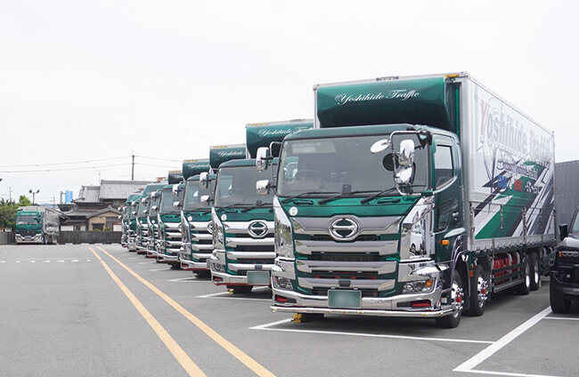 駐車場に並ぶ株式会社吉秀トラフィックのトラック