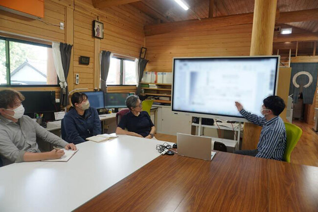 大型の電子黒板を使って会議を行う様子