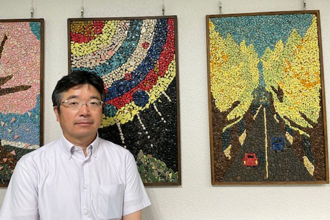 設立の精神を守りながら現場で見守る橋本孝広常務理事。利用者の作品の前で