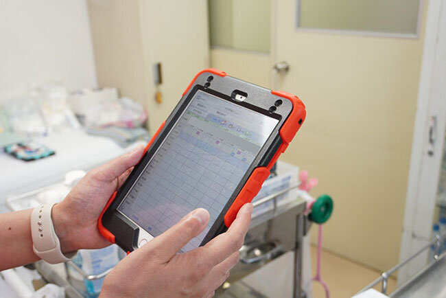 タブレット端末で入居者のバイタルデータを確認する様子