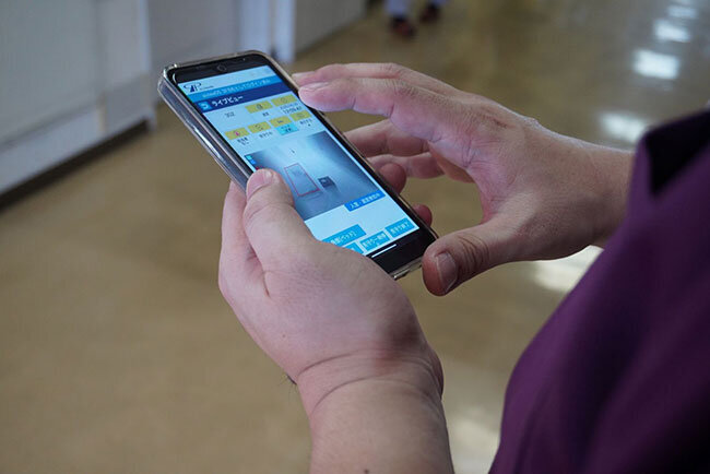 緊急通知を受けてスマートフォンから居室の様子を確認する様子