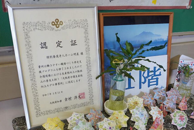 明星が受け取った大阪府介護生産性向上モデル事業所の認定証