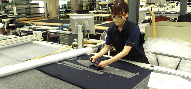 自動裁断システムに型紙をセットしているところ