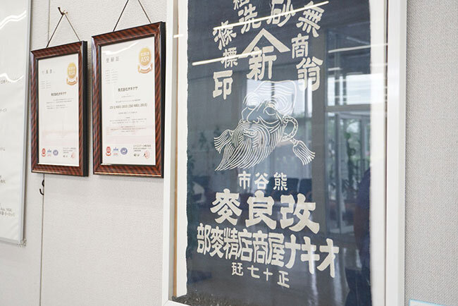 オキナヤの本社ロビーに展示されている戦前の屋号を染め抜いた織物